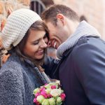 64710962 – picture showing happy couple hugging with flowers in the city